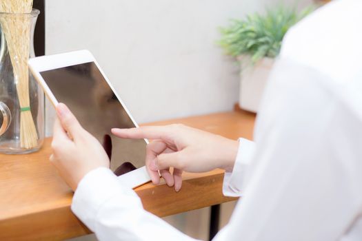 Closeup beautiful asian businesswoman holding tablet, woman hand touch screen using digital tablet computer and working internet online coffee shop, communication concept.