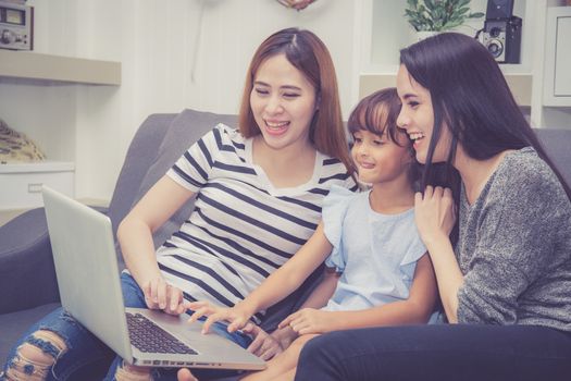 Mother, Aunt and kid having time together lerning with using laptop computer at home with relax and happy on couch, education and lifestyle concept.