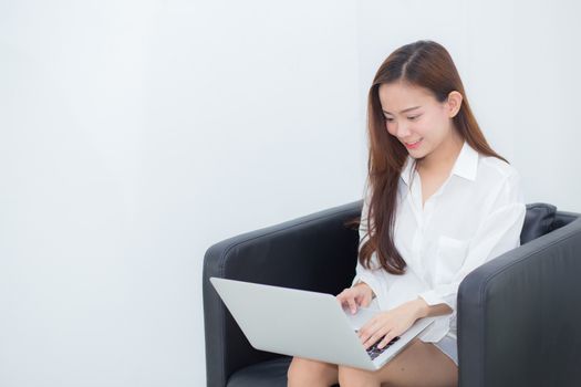 Beautiful of portrait young asian woman using laptop for leisure on sofa, girl working online internet with notebook freelance, communication business concept.