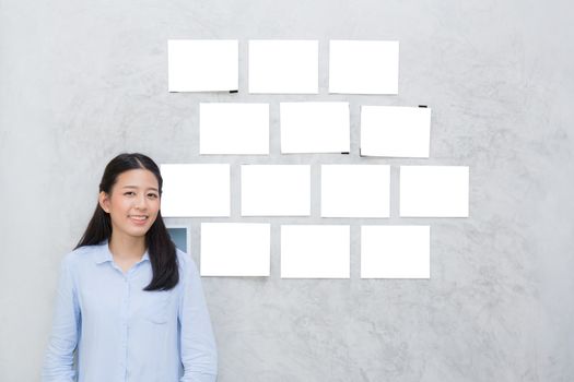 Beautiful of portrait asian young woman standing with picture gallery copy space on wall texture cement background.