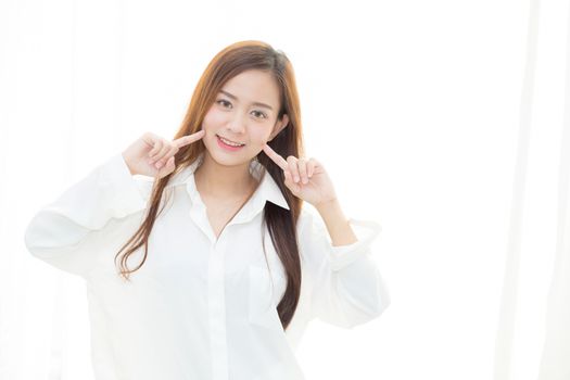 Portrait of beautiful woman makeup of cosmetic, girl hand touch cheek and smile attractive standing the window, face of beauty perfect with wellness, healthcare concept.
