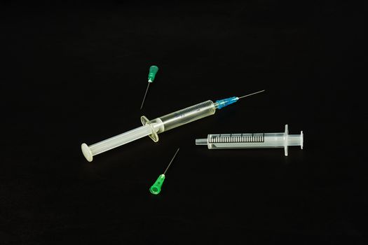 Medical syringe and needles on a black background