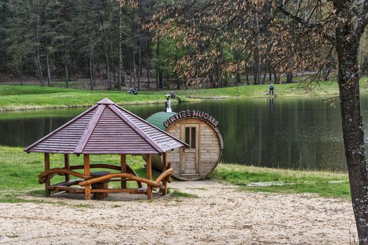 On the shore of the forest lake there is a bathhouse and a gazebo