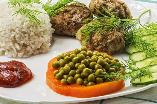 Home food. Cutlet from minced meat with boiled rice and fresh vegetables