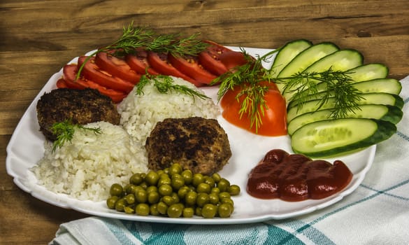 Home food. Fresh vegetables and boiled rice with meat cutlets