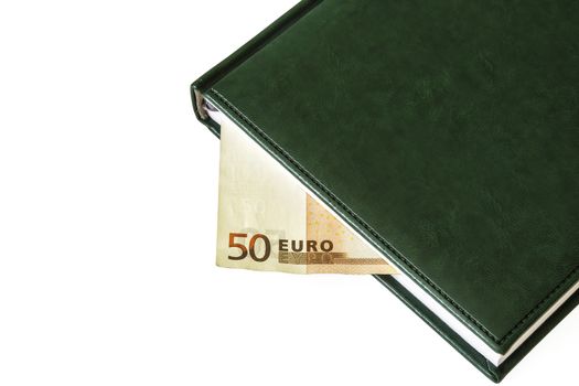 Between the sheets of the closed diary is visible part of the bill of 50 euros