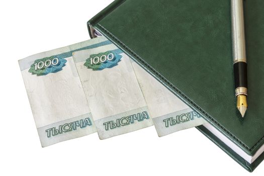 From a closed diary, you can see the fountain pen and Russian rubles on a white background