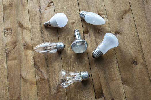 Lamps with different cap lie on a wooden surface