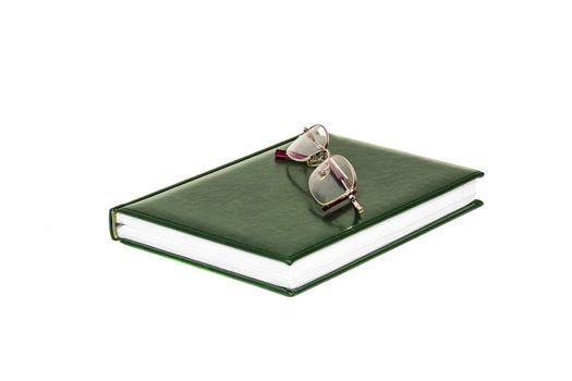 Diary and eyeglasses lie on a white background