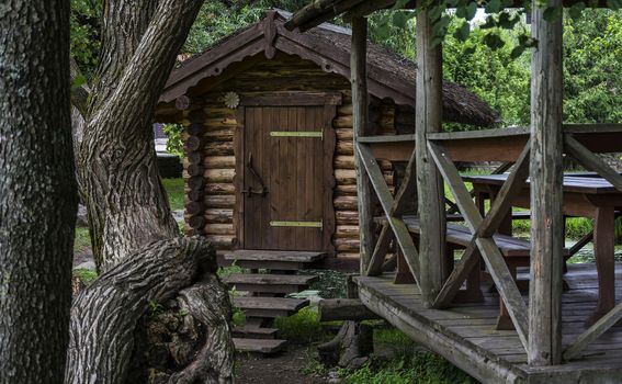 Among the trees is a wooden building and a wooden pergola