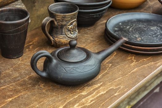 On the wooden table is ceramic hand-made pottery