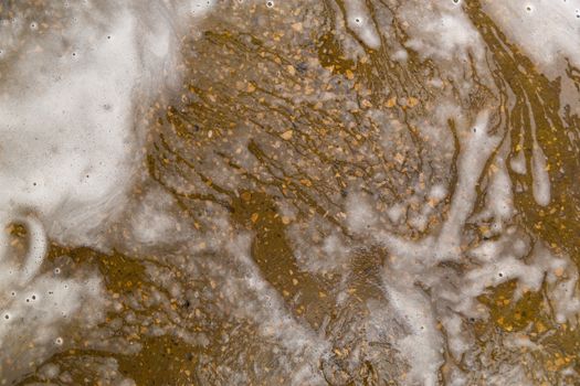 Floor with soap sud waste in car washing garage. Full frame close-up with selective focus and blur.