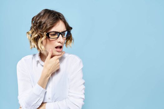 Business woman in a light shirt on a blue background gestures with her hands emotions model work. High quality photo