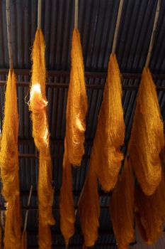 Dyed wool hanging to dry in souk in Marrakech Morocco Marrakechs Sebbaghine vibrant Dyers Souk. Skeins of red, blue, yellow, gold hanging from the ceiling with beautiful light shafting making a magical scene of ancient berber traditions High quality photo