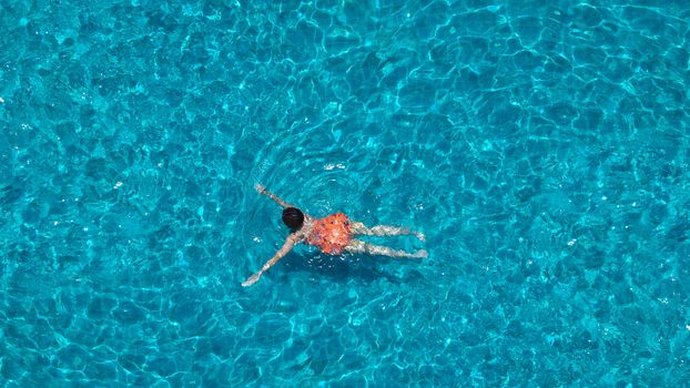 Swimming pool blue color clear water and people enjoying in summer sunny day and top view angle.