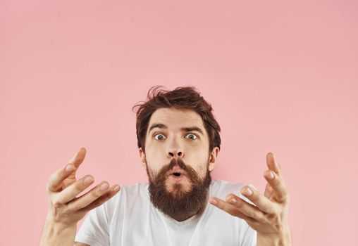 man emotions model gesturing with hands pink background close-up. High quality photo