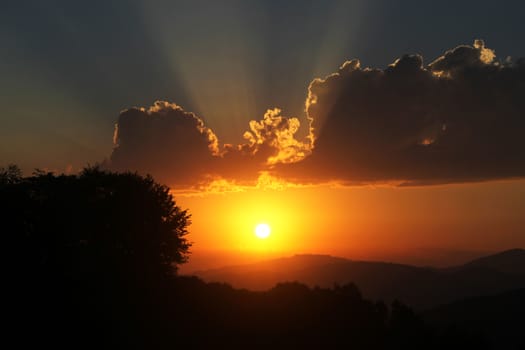 Mountain cloudscape and landscape at sunset in Georgia. Horizon in mountain range.cloudy vivid sunlight, fire storm cloudy view.