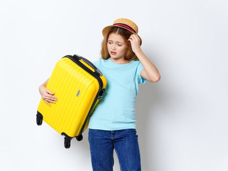 Girl with yellow suitcase vacation travel passenger gray background studio
