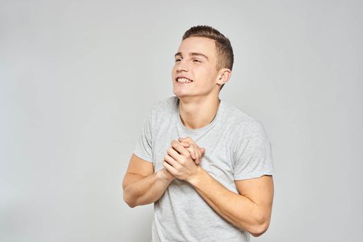 handsome man in light t-shirt cropped view emotion studio isolated background. High quality photo