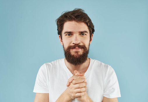 portrait of happy man on blue background in white t-shirt with open mouth emotions. High quality photo