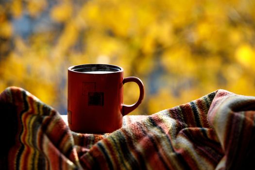 Red coffee cup over autumn background