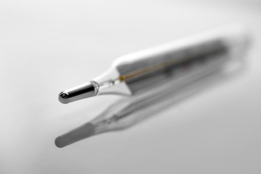 Mercury thermometer. Selective focus, gray background