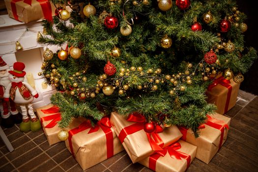 Beautiful Christmas gift boxes on floor near fir tree in the room