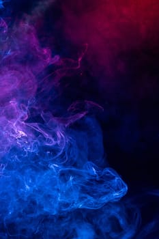 Conceptual image of colorful red and blue color smoke isolated on dark black background, Halloween concept design element.