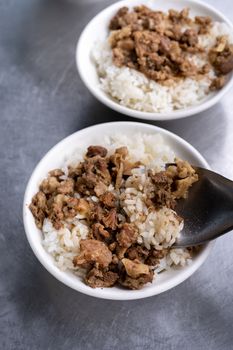 Braised meat rice, stewed pork over cooked rice in Tainan, Taiwan. Taiwanese famous traditional street food delicacy. Travel design concept, closeup.