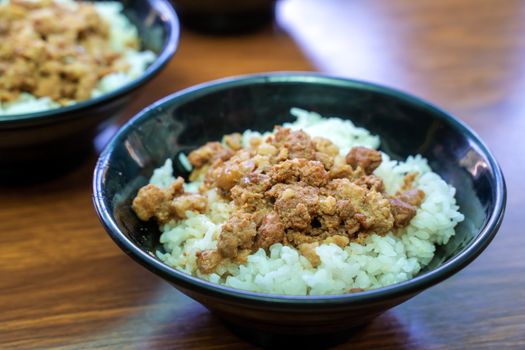 Braised meat rice, stewed pork over cooked rice in Tainan, Taiwan. Taiwanese famous traditional street food delicacy. Travel design concept, closeup.