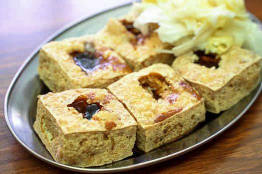 Deep fried stinky tofu, fermented bean curd with pickled cabbage vegetable, famous and delicious street food in Taiwan, lifestyle.
