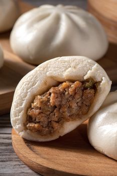 Close up of fresh delicious baozi, Chinese steamed meat bun is ready to eat on serving plate and steamer, close up, copy space product design concept.