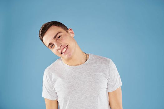 Emotional man in white t-shirt cropped view on blue background lifestyle. High quality photo