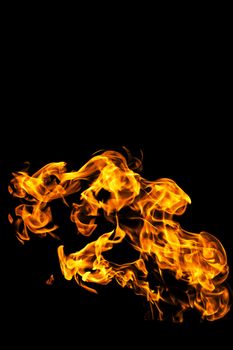 Fire flames on black background isolated. Burning gas or gasoline burns with fire and flames. Flaming burning sparks close-up, fire patterns. Infernal glow of fire in the dark with copy-space