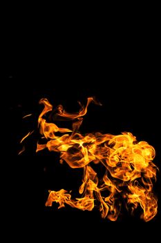 Fire flames on black background isolated. Burning gas or gasoline burns with fire and flames. Flaming burning sparks close-up, fire patterns. Infernal glow of fire in the dark with copy-space