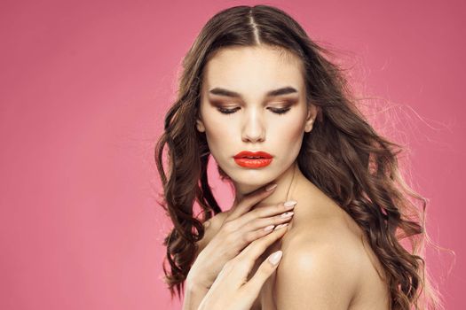 Beautiful woman with red lips on a pink background nude shoulders cropped view. High quality photo