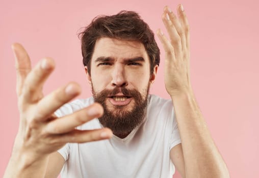 Portrait of a man in a white T-shirt on a pink background close-up model. High quality photo