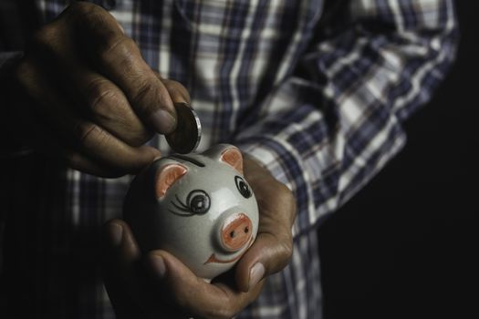 Saving money concept and hand putting money coin into piggy bank. Accounting and business concept.