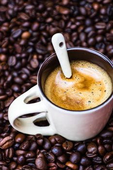 Coffee cup with roasted coffee beans on red background, coffee concept, close up coffee photo