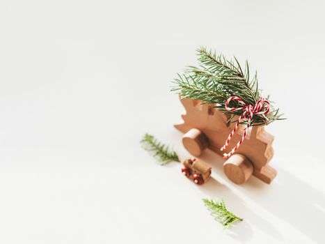 Two wooden trains with tied fir tree coniferous twigs. Dad and baby. Cute symbol of Christmas tree brought home for New Year celebration. Winter holiday spirit. Copy space.