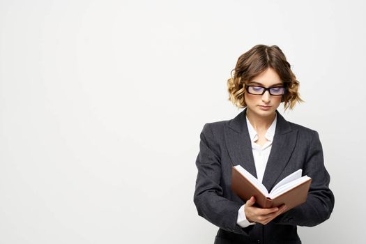 Business woman in a classic suit with a notebook in her hand and glasses on her face Copy Space. High quality photo