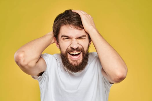 Bearded man in white t-shirt emotions close-up fun yellow background. High quality photo