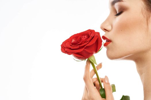 Beautiful woman with red rose near face makeup naked shoulders portrait. High quality photo