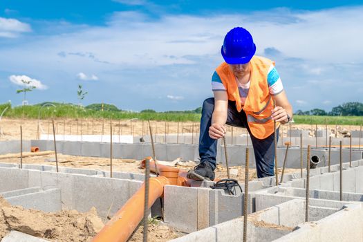 laying plastic pipes to the foundation of the building.