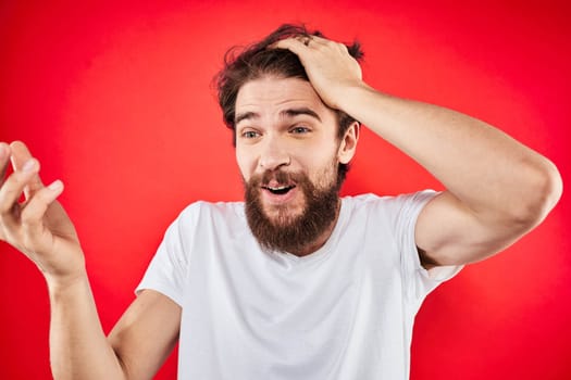 Bearded man fun emotions lifestyle cropped view white t-shirt red background. High quality photo