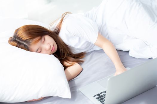 Beautiful of portrait young asian woman with laptop lying down in bedroom, girl tired sleep and relax with computer notebook, resting and healthcare concept.