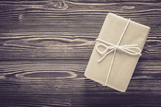 Above package gift box and rope on wood table texture background with birthday copy space, top view, holiday celebration concept.