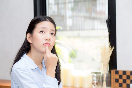 Portrait of beautiful young asian woman happiness and think sitting at cafe shop, businesswoman is a smile, freelance people concept.