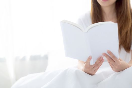 Beautiful of portrait young asian woman relax sitting reading book on bedroom at home, girl study literature, education and llifestyle concept.
