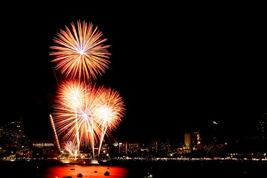 Many flashing fireworks with night cityscape background celebrate New Year.